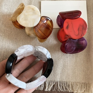 Detail of chunky acrylic link bracelets showing marble texture and tortoise pattern