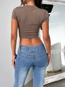 Rear view of slim fit brown crop top paired with high-waisted blue denim jeans