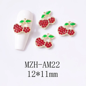 Detail showing red rhinestone cherry nail art charms with green leaves on white nails