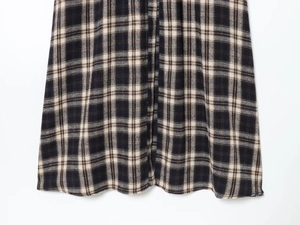 Macro view of navy and beige plaid fabric texture and hem detail on midi dress