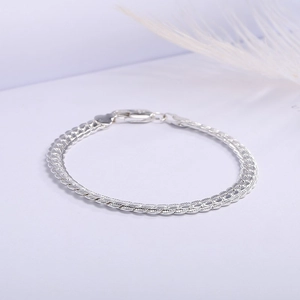 Detail of silver flat curb chain necklace with lobster clasp and heart tag on white