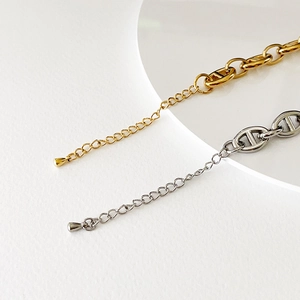 Detail of 18k gold and silver anchor link chains with adjustable drop pendants