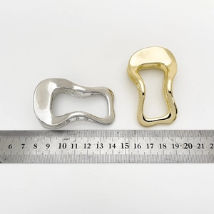 Detailed size measurement of irregular silver and gold alloy hair clips with a ruler