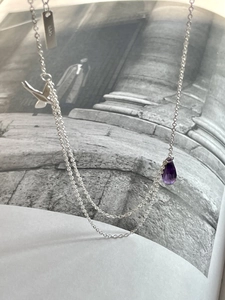Close-up of S925 sterling silver swallow necklace with purple teardrop gemstone charm