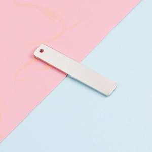 Macro detail of polished silver rectangular stainless steel tag on textured paper