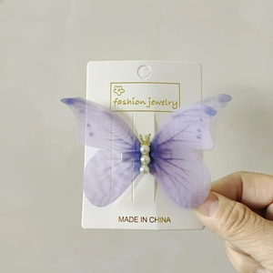 Detailed view of lavender tulle butterfly hair clip with pearl beads on display card