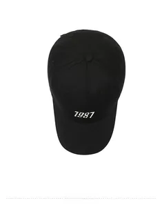 Top view of a black cotton baseball cap featuring a white 1987 embroidery on the front