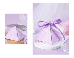 Detail of purple pyramid wedding favor box with white floral pattern and silk ribbon bow