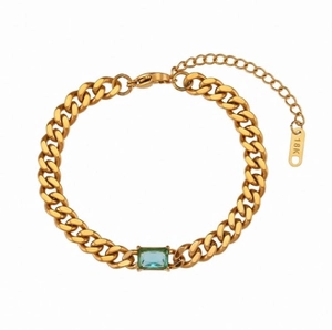 Vista macro del bracciale a catena cubana placcato oro con zircone blu e incisione 18K