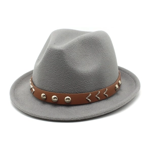 Detail of grey fedora hat with brown leather band, silver studs, and V-shaped metal buckle