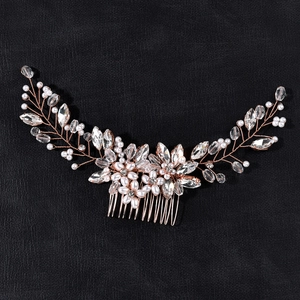 Close-up of handmade bridal hair comb with pearls and rhinestones on rose gold wire