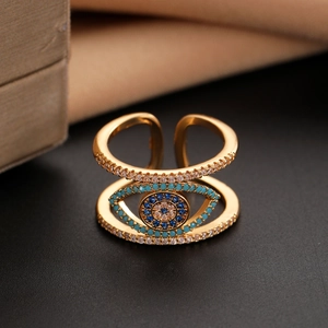 Macro detail of gold evil eye ring with blue and white zircon stones in an open double layer