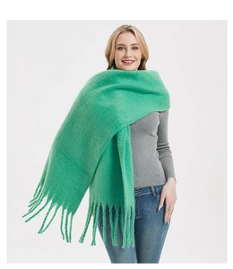 Detailed view of the soft mohair texture and long fringe on the green winter scarf