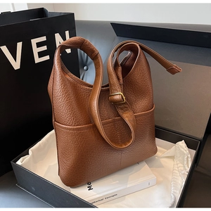 Détail de la boucle en laiton réglable et du cuir au motif litchi sur le sac hobo marron