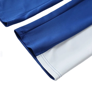 Detailed close-up of blue and white paneled joggers showing precision double stitching