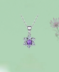 Détail du pendentif fleur en argent s925 avec pierres violettes et blanches sur une chaîne