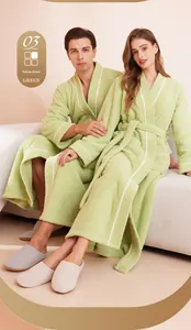 Detail of yellow-green plush bathrobe with white piping and matching waist belt