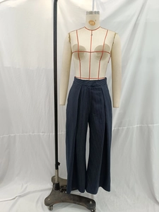 Détail du pantalon large à rayures verticales bleu marine avec taille haute drapée