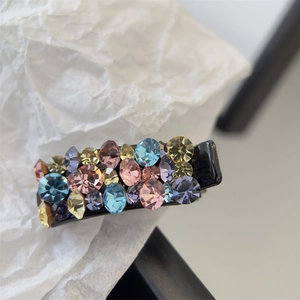 Vue détaillée d'une mini pince à cheveux avec strass colorés bleus roses jaunes et violets