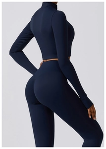 Détail de l'ensemble de yoga bleu foncé montrant la coupe haute et le galbe du dos du modèle