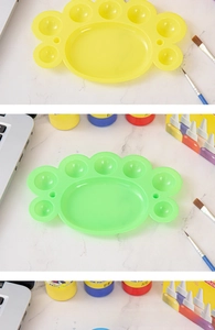 Close-up of foot-shaped plastic palettes in yellow and green for watercolor painting