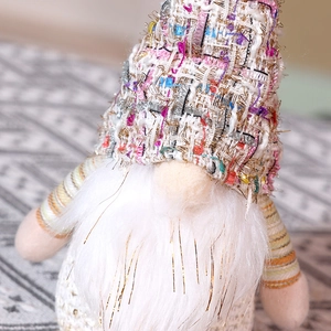 Vue détaillée d'un gnome de Noël crème avec bonnet en tweed et barbe en fausse fourrure brillante