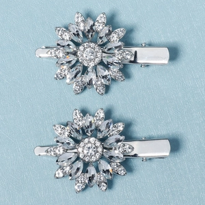 Sparkling sunflower hair clips with rhinestones on a minimalist blue textured background
