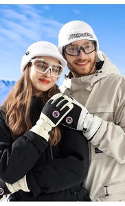 Detail of waterproof ski gloves paired with a matching winter hat and skiing goggles