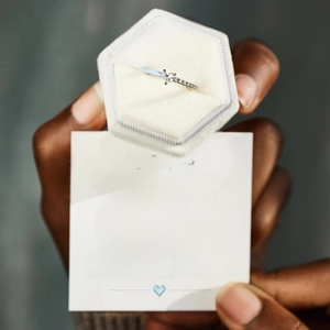 Macro detail of heart-cut zircon silver ring with My Daughter message card in a velvet box