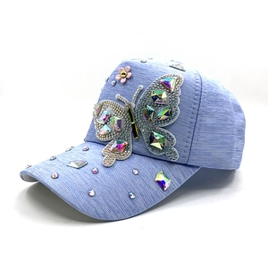 Light blue baseball cap featuring a large rhinestone butterfly and pink pearl flower