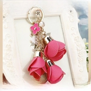 Detail of fuchsia tulip leather keychain with pink clover charm and golden clasp