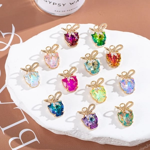 Colorful crystal fruit pendants with gold bow and rhinestones on white display