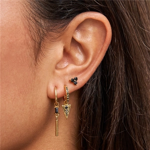Close-up of gold flower earrings set with black faceted stones worn by model