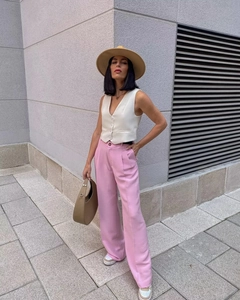 Style urbain avec un gilet à boutons blanc associé à un pantalon large rose et un chapeau
