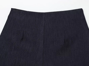 Détail du pantalon en sergé indigo à taille haute avec plis et coutures contrastées