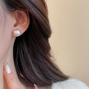 Close-up of elegant square pearl earrings on model with chic vintage french style