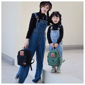 Detail of canvas backpack with smiley face patch and zipper closure for parents and kids
