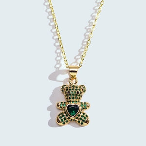 Detail of bear pendant featuring green pave zircon and heart-shaped gemstone center