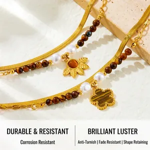 Detailed close-up of tiger eye stone beads and clover pendants on double-layered chain