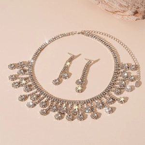 Ensemble bijoux 2 pièces fleur argentée avec pompons de cristaux sur fond beige élégant
