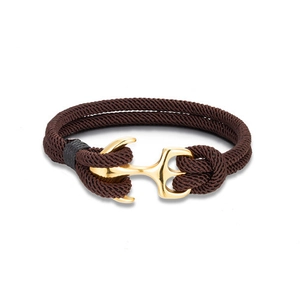 Detail of a brown woven rope bracelet featuring a polished gold anchor metal buckle