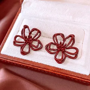 Elegant hollow flower earrings in deep red lacquer finish inside a gift box