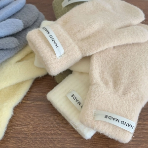 Close-up of soft faux mink fur gloves in pastel colors with handmade woven labels