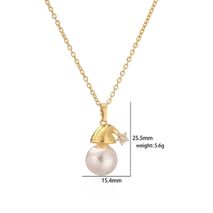 Détail du collier de Noël en or avec chapeau de Père Noël, perle et pendentif étoile serti