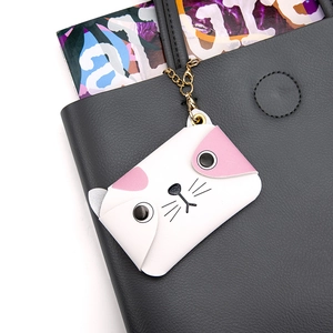 Süßer weißer Katzen-Lederanhänger mit Goldkette an einer dunklen Handtasche