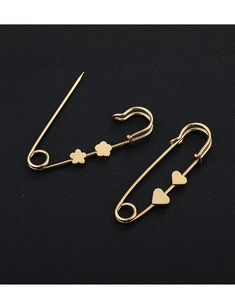 Detailed macro of golden metal pins with delicate flower and heart shaped ornaments