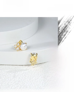Detail view of elegant gold pearl earrings with sparkling zircon stones in a luxury set