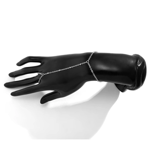 Detailed view of silver finger ring bracelet with metal chains and pearls on a model hand