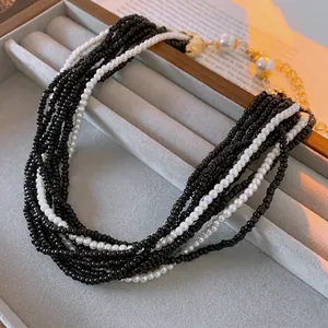 Elegant multilayer beaded necklace with black and white faux pearls and gold clasp