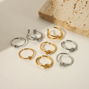 Minimalist knot-style stainless steel rings in gold and silver finish on stone decor